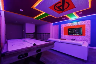 a purple room with a ping pong table and a tv at Close to Disney! Pool, Spa, Game, & Movie Room! in Kissimmee