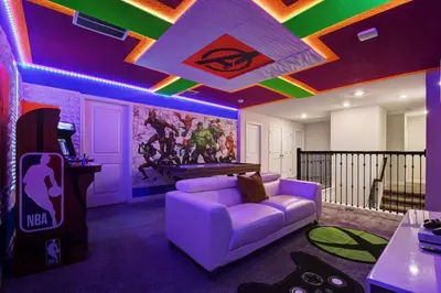 a living room with a purple couch and a pool table at Close to Disney! Pool, Spa, Game, & Movie Room! in Kissimmee