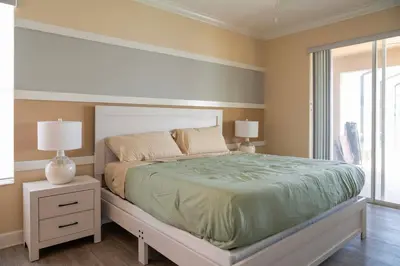 a bedroom with a bed and two lamps and a window at 5BR 4BA Pool Pool Table Near Disney in Kissimmee