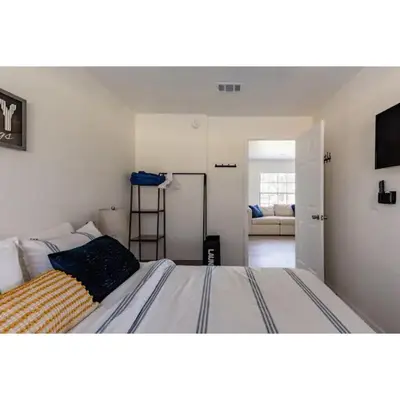 a bedroom with a bed and a living room at Dream Getaway Nr Disney! Own Pool & Modern Feel! in Orlando