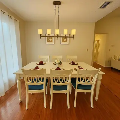 a dining room with a white table and chairs at Casa 3Q c/ Piscina — 10 min da Disney in Kissimmee