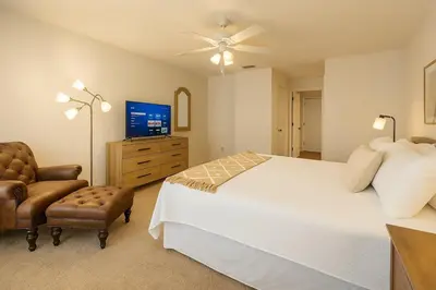 a bedroom with a bed and a tv and a chair at Casa 3Q c/ Piscina — 10 min da Disney in Kissimmee