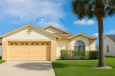 a house with a garage and a palm tree at Casa 3Q c/ Piscina — 10 min da Disney in Kissimmee