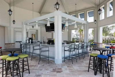 a bar in a pavilion with chairs and tables at Close to Disney! Pool/Spa/Game & Movie room! in Kissimmee