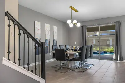 a dining room with a table and black chairs at Close to Disney! Pool/Spa/Game & Movie room! in Kissimmee