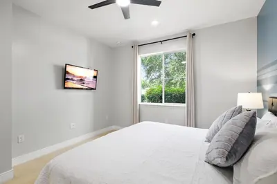 a white bedroom with a bed and a window at Villa near Orlando's Attractions in Orlando
