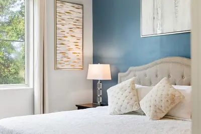 a bedroom with a white bed with a blue wall at Villa near Orlando's Attractions in Orlando
