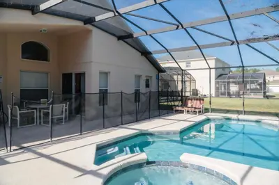 a swimming pool with a patio and a house at Gated Pool Home 20 Min to Disney, Uni, MCO in Kissimmee
