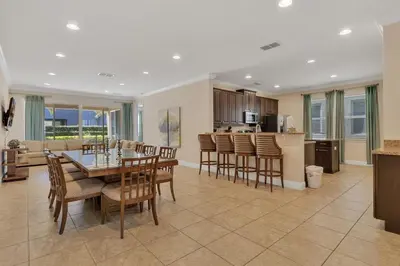 a dining room and kitchen with a table and chairs at 480 Lasso Dr. · 480 Villa - Large Luxury 7BD Home - SpaPool in Orlando