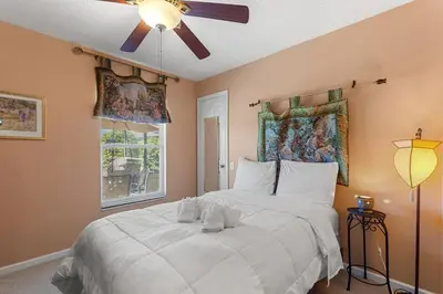 a bedroom with a large white bed with a ceiling fan at 2232 Wyndham Palms Way in Kissimmee