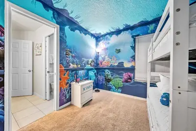a bedroom with a blue ocean themed wall at Cozy Villa 08 BedroomsPoolGame Room in Kissimmee