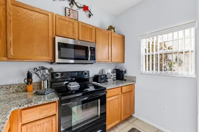 a kitchen with a stove and a microwave at Family Escape! HotTub+Grill+Disney! in Kissimmee