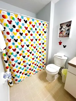 a bathroom with a shower curtain with a toilet at Hot Tub, BBQ - Near Disney Fun! in Kissimmee
