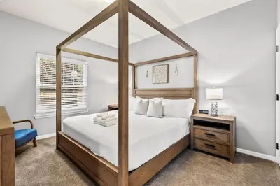 a bedroom with a large bed with a wooden frame at Luxury 4BR Resort Villa @ Lucaya Village in Kissimmee