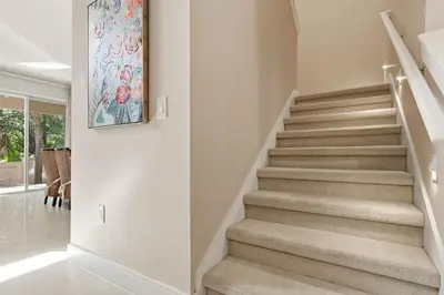 a staircase in a home with a painting on the wall at Two Story Resort Retreat Near Theme Parks in Orlando