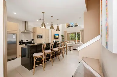 a kitchen and dining room with a bar with stools at Two Story Resort Retreat Near Theme Parks in Orlando