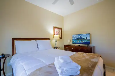 a bedroom with a white bed with towels on it at Paradise Found: Private 5-Bed Townhouse Oasis in Kissimmee
