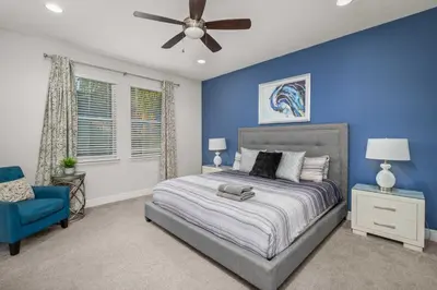 a blue bedroom with a bed and a ceiling fan at Private Heated Pool Game room 6MI to Disney in Orlando