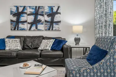 a living room with a couch and a chair at Private Heated Pool Game room 6MI to Disney in Orlando