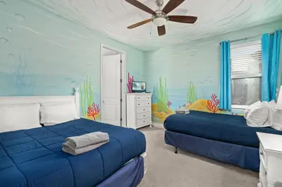 a bedroom with two beds and a ceiling fan at Private Heated Pool Game room 6MI to Disney in Orlando