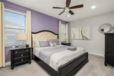 a bedroom with a bed and a ceiling fan at Private Heated Pool Game room 6MI to Disney in Orlando