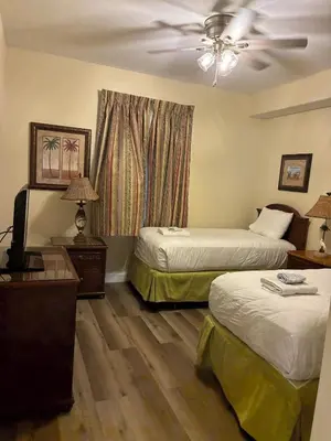 a hotel room with two beds and a ceiling fan at Blue Heron Beach Resort Tower 12 FL 1204 Fully Furnished in Orlando