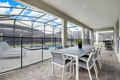 a dining room with a white table and chairs at Your Beautiful Hideaway 9-Bedroom Luxury Villa in Kissimmee