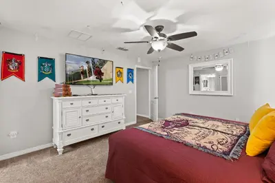 a bedroom with a bed and a ceiling fan at Themed Villa with Private Pool Games Massage Chair in Kissimmee