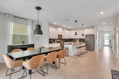 a large kitchen with a dining table and chairs at Casa 6Q c/ Piscina & Sala de Jogos — Storey Lake in Kissimmee