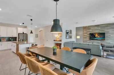 a kitchen and living room with a table and chairs at Casa 6Q c/ Piscina & Sala de Jogos — Storey Lake in Kissimmee