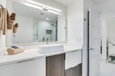 a white bathroom with a sink and a mirror at Spacious 4BR,3BA Home Near Disney in Kissimmee