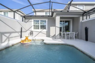 a swimming pool in the backyard of a house at Townhome 5Q c/ Piscina – 8mi da Disney in Kissimmee