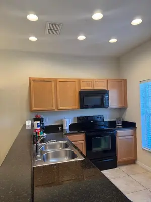 a kitchen with a sink and a microwave at Cosy Family Home in encantada kissimee in Kissimmee