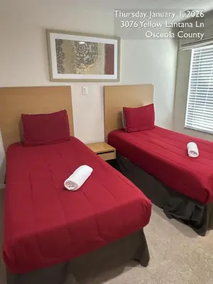 two beds with red covers in a room at Cosy Family Home in encantada kissimee in Kissimmee
