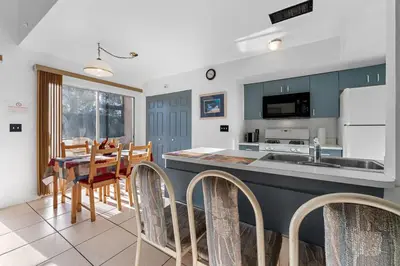 a kitchen with a sink and a table with chairs at Mango Keys Getaway Near Theme Parks in Kissimmee