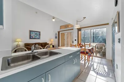 a kitchen with a sink and a living room at Mango Keys Getaway Near Theme Parks in Kissimmee