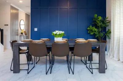 a dining room table with chairs and a blue wall at Casa 5Q Storey Lake Resort c/ Piscina Privada in Kissimmee