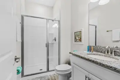 a white bathroom with a shower and a toilet at Casa c/ 4Q no Storey Lake Resort c/ Piscina in Kissimmee