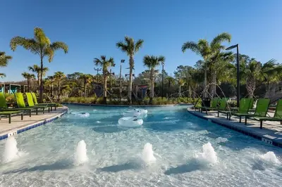a pool at a resort with chairs and palm trees at Casa c/ 4Q no Storey Lake Resort c/ Piscina in Kissimmee