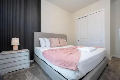 a bedroom with a bed with a pink blanket and a nightstand at 7547 NEW 5 minutes from Disney 5BD 5BH 15P in Orlando