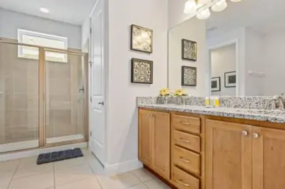 a bathroom with a shower and a sink and a mirror at 381 Fantastic Home Near Disney 5BD 5BT 14P in Orlando
