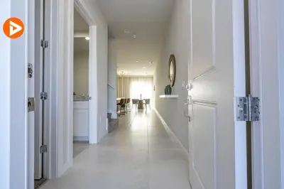 a hallway with white walls and a long hallway with a table at (7556) 3-Bedroom House in Resort near Disney in Orlando