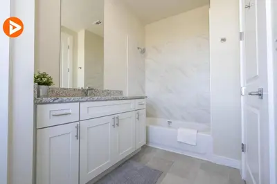a bathroom with white cabinets and a tub and a sink at (7556) 3-Bedroom House in Resort near Disney in Orlando