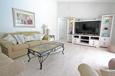 a living room with a couch and a tv at 20 mins Disney, Private Heated Pool & Spa, Games Room, Spacious, Good for Groups in Orlando