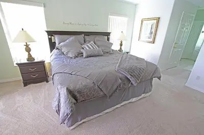 a bedroom with a large bed with purple sheets and pillows at 20 mins Disney, Private Heated Pool & Spa, Games Room, Spacious, Good for Groups in Orlando
