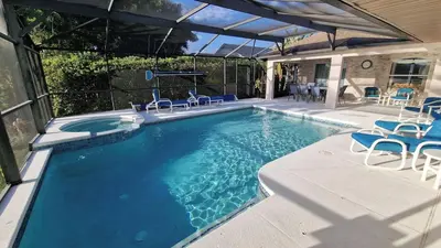 a large swimming pool with chairs and a table at 20 mins Disney, Private Heated Pool & Spa, Games Room, Spacious, Good for Groups in Orlando