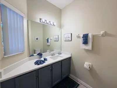 a bathroom with a sink and a large mirror at The Family Den in Kissimmee