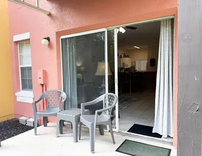 two chairs and a table on the porch of a house at The Family Den in Kissimmee