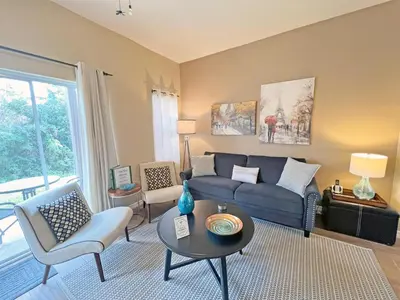 a living room with a blue couch and chairs at Sun Key Getaway in Kissimmee