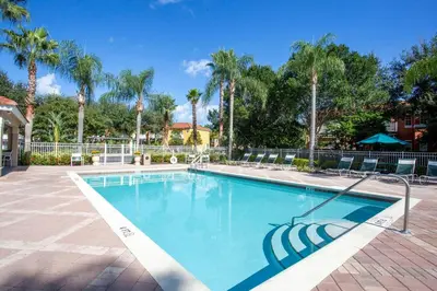 a swimming pool in a resort with palm trees at Magari at Emerald Island in Kissimmee